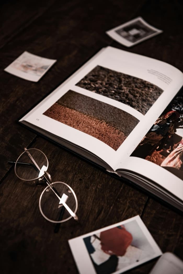 Open art book with photographs on a dark wood table