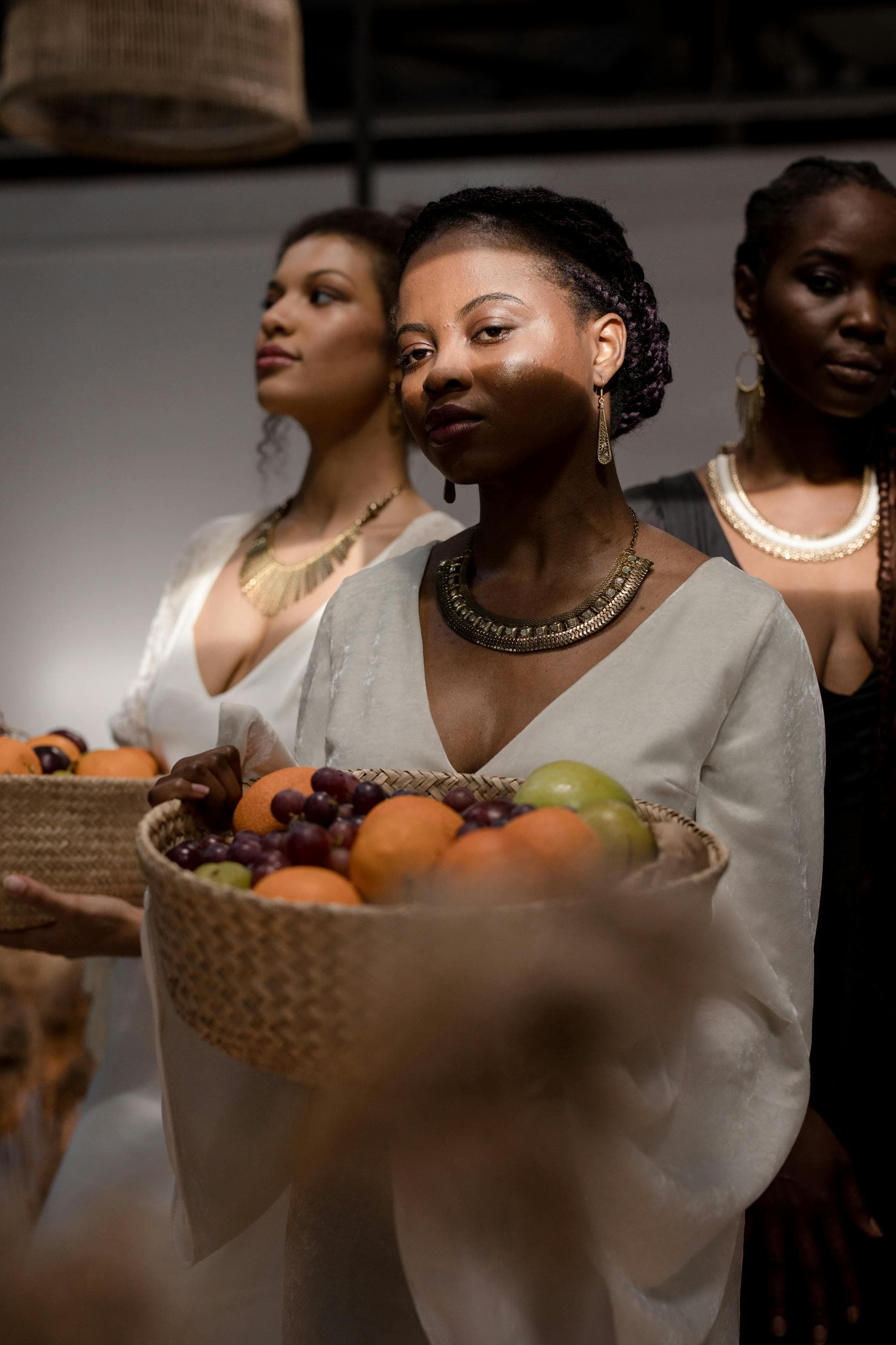 Editorial portrait of a model in white holding a basket of fruit